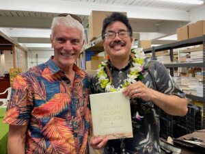 Lee Tonouchi holds his book, "Oriental Fadda and Son," next to Buddy Bess.