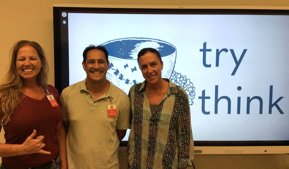 Brandy Chang, Rob Chang, and Tammy Jones smile in front of the Try Think pewa log on a monitor at one of the program sites.